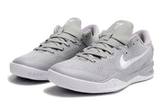 Pair of light gray Kobe 8 basketball sneakers with white swooshes and matching soles.