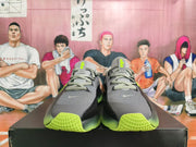 Front view of gray Nike basketball shoes with lace-up closure and bright green accents.