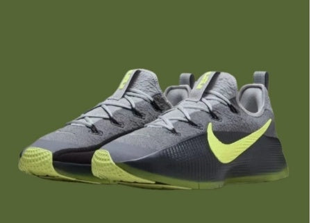 Pair of gray and lime-green Nike training shoes against an olive-green background.
