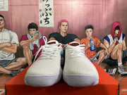 Front view of white Nike shoes with white laces and textured uppers.