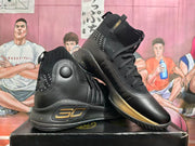 Side view of black high-top basketball shoes with gold accents and visible 30 branding.