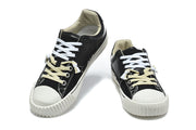 Pair of black low-top sneakers with white toe caps, contrast laces, and light-colored lining.