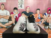 Front view of Nike Kobe basketball shoes showing white and black laces, gold tongue logos, and printed toe details