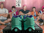Rear view of gray-green Nike sneakers showing black Swoosh details, purple collar lining, and black heel sections.