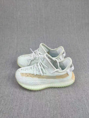 Angled view of the pale gray sneaker pair with woven-look uppers and tan side stripes.