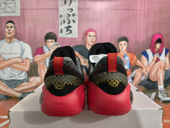 Rear view of black and red basketball sneakers showing red heel sections, patterned heel panels, and a basketball-themed background.
