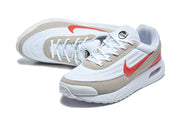 Angled top view of the white and red Nike Air Max Verse sneakers with taupe overlays and white laces.