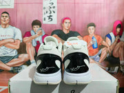 Rear view of white and black Nike basketball sneakers showing glossy black heel panels, white midsoles, and heel branding.