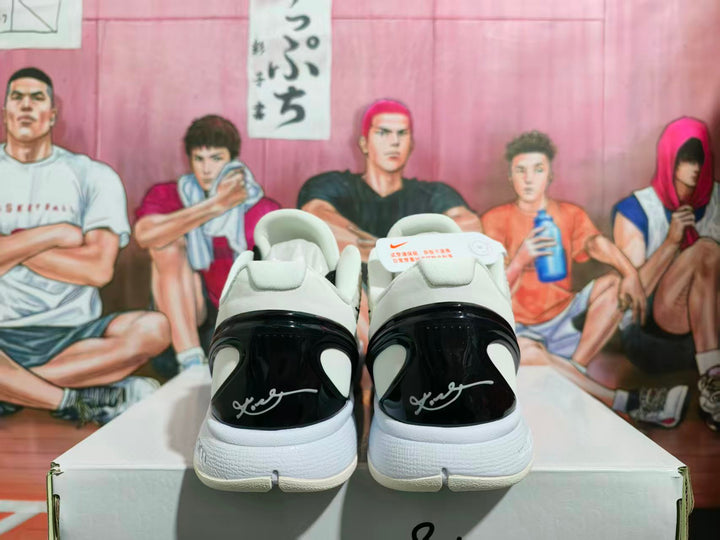 Rear view of white and black Nike basketball sneakers showing glossy black heel panels, white midsoles, and heel branding.