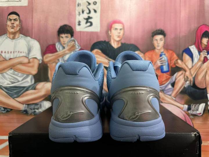 Rear view of blue-gray Nike Kobe basketball shoes showing heel panels and sculpted soles