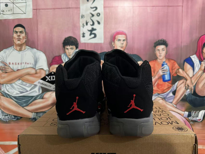 Rear view of black Jordan 23 high-top sneakers with red heel logos and gray soles.