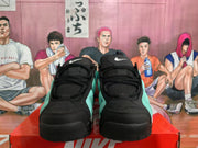 Front view of the black and green Nike sneakers showing the black laces, padded tongues, and toe areas.