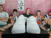 Front view of the pair of white Nike basketball sneakers, showing the laces, textured uppers, and toe areas.