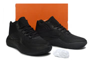 All-black Nike basketball sneakers displayed in front of an orange shoe box.
