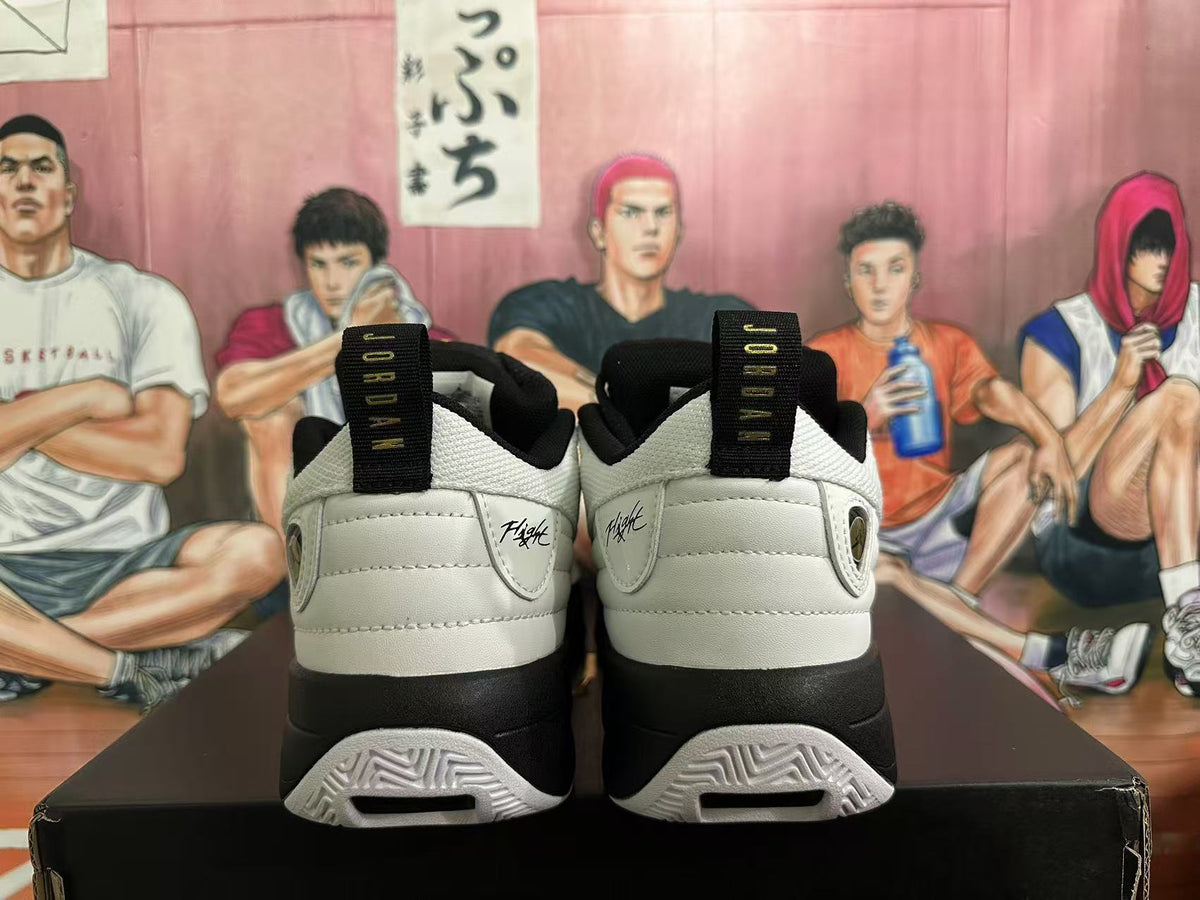 Rear view of white and black Jordan sneakers showing heel branding, pull tabs and patterned outsole details.