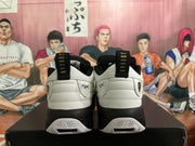 Rear view of white and black Jordan sneakers showing heel branding, pull tabs and patterned outsole details.