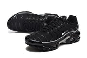 Angled top view of black Nike Air Max Plus sneakers with white side Swooshes and silver-toned accents.