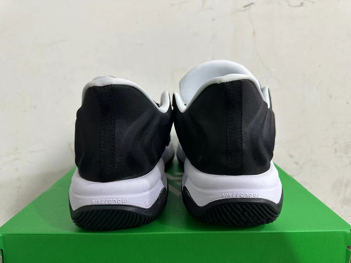 Rear view of black and white Nike sneakers on a green box