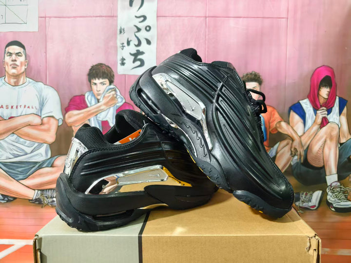 Pair of black and silver basketball-style sneakers shown from the side and outsole on a box.