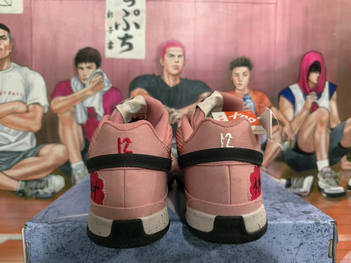Rear view of watermelon-red Nike basketball sneakers showing black heel bands, contrasting heel graphics, and speckled midsoles.