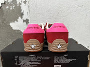 Rear view of red and pink Converse low-top sneakers with tan soles and star-shaped heel details.