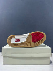 Bottom view of the sneaker showing the gum-colored outsole, red circular traction section, and Nike branding.
