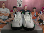 Front view showing white laces, white uppers, green tongue logos, and black toe-outsole accents.
