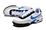 Angled view of white and blue Nike Air Max Plus sneakers with black lace-panel trim.