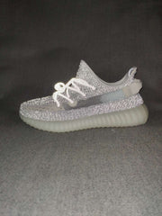 Side profile of the silver-gray sneaker showing the outer stripe, low-top shape, and ribbed translucent sole.