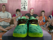 Front view of the pair showing black laces, lime tongue accents, green patterned uppers, and bright translucent outsoles.