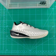 Side view of the metallic silver sneaker displayed against a green measuring and cutting mat.