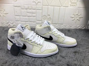 Pair of cream, white, and black mid-top sneakers shown from an angled front view, with an extra black lace accessory in a clear bag.