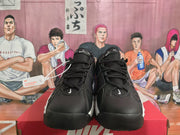 Front view of black Nike sneakers showing laces, perforated toe panels, and small white Swoosh details.