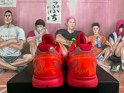 Rear view of the red sneakers showing translucent heel elements and red outsoles.