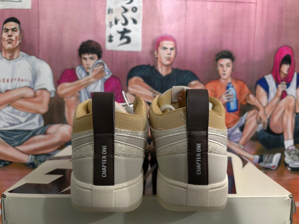 Rear view of beige low-top sneakers showing dark “CHAPTER ONE” heel pull tabs, tan collar lining, and textured white outsole.