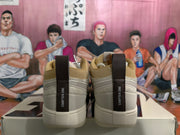 Rear view of beige low-top sneakers showing dark “CHAPTER ONE” heel pull tabs, tan collar lining, and textured white outsole.