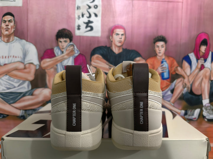 Rear view of beige low-top sneakers showing dark “CHAPTER ONE” heel pull tabs, tan collar lining, and textured white outsole.