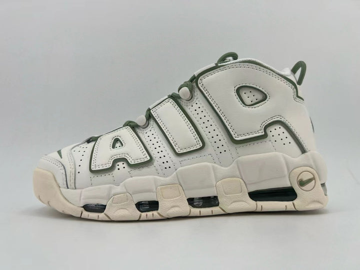 Side view of a white Nike Air More Uptempo sneaker with dark green accents, oversized AIR lettering, and a chunky segmented sole.
