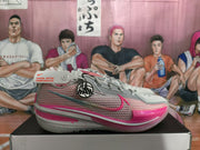 Side profile of a grey and pink Nike basketball sneaker showing the mesh-textured upper, Swoosh detail and pink forefoot accent.