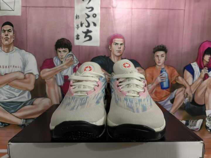 Front view of grey and blue Nike basketball sneakers with pink accents and black outsoles displayed on a box.