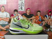Side profile of the green Nike basketball shoe showing the mesh upper, dark swoosh, layered midsole, and translucent outsole.