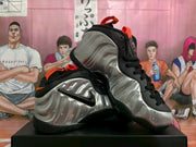 Pair of silver, black and orange Nike sneakers shown from an angled side view.