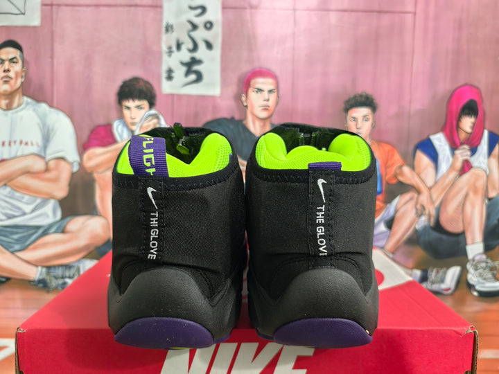 Rear view of black Nike high-top sneakers with neon yellow collars, purple soles, and “THE GLOVE” heel branding on a Nike box.