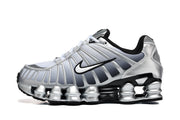 Side profile of a silver Nike Shox TL sneaker with a black-and-white Swoosh.