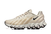Side view of a cream and beige Nike Air Max DN sneaker with a sculpted circular-element sole