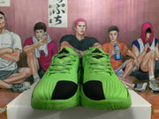 Front view of bright green low-top sneakers with black toe panels and matching patterned laces.