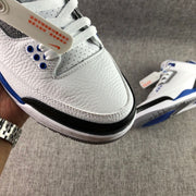 Close-up of the perforated white toe box, gray lace panel, blue eyelets, and black toe overlay.