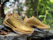 Angled view of gold Kobe 5 shoes with lace and side details