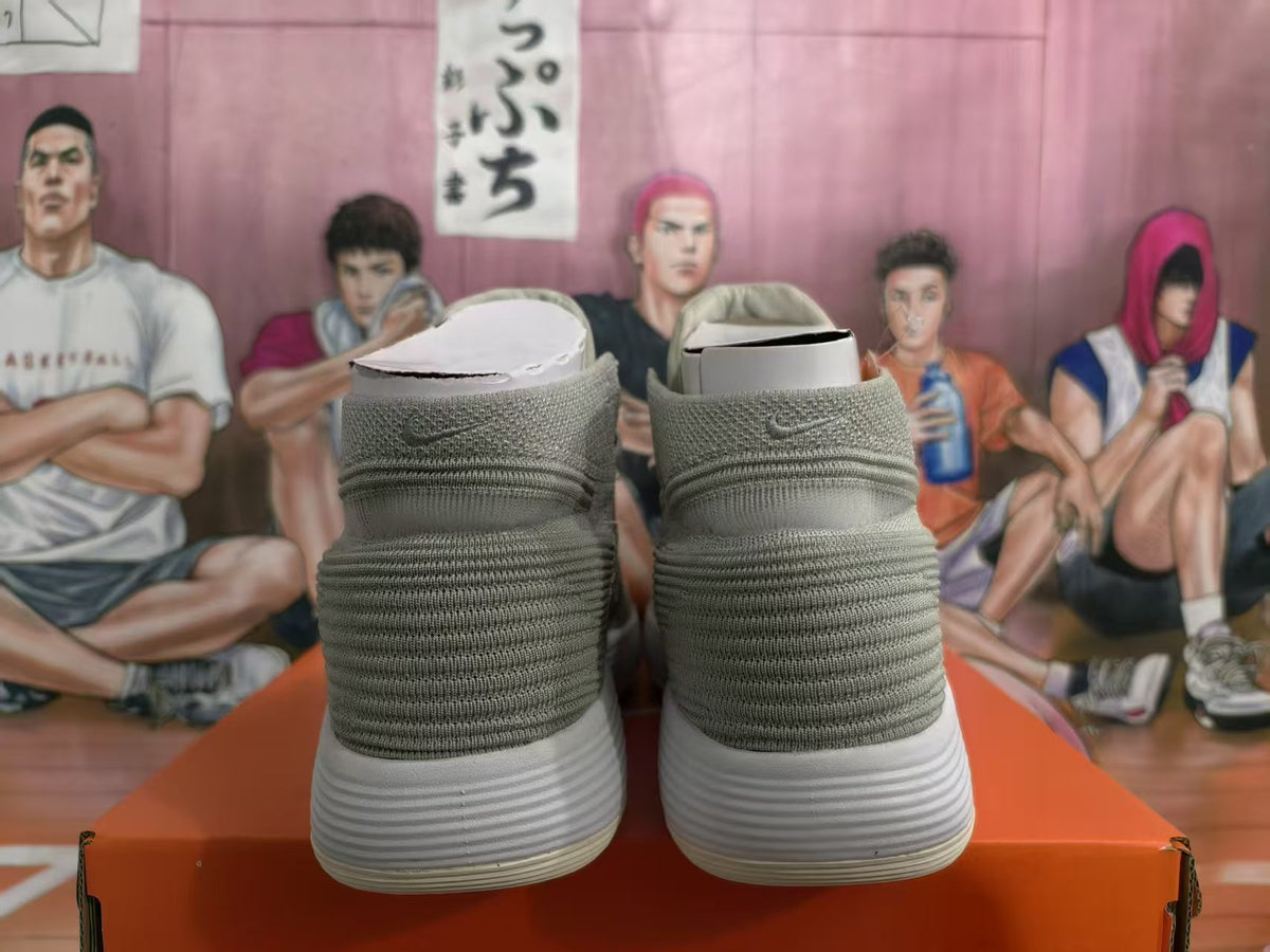 Rear view of light gray high-top sneakers with ribbed white soles