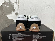 Rear view of black Converse sneakers with white heel panels and gum-colored outsoles.